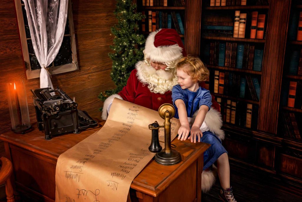 Little girl with Santa reading the list