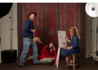 Dad on a wooden horse, daughter painting in maternity portrait.