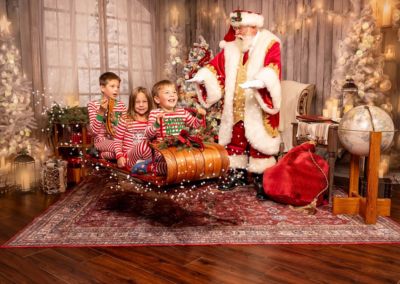 Santa with 3 kids riding a magic sled in Michael Holl's studio