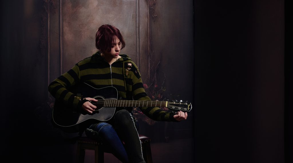 Dark and moody image of girl playing guitar