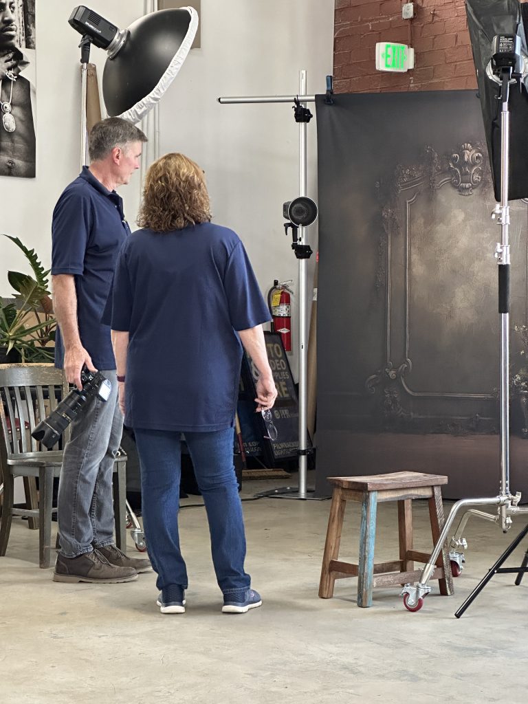 Photographers in a studio setting up backdrops and lights