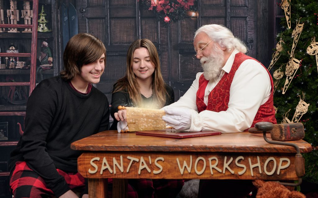 Santa reading the list with two teenagers