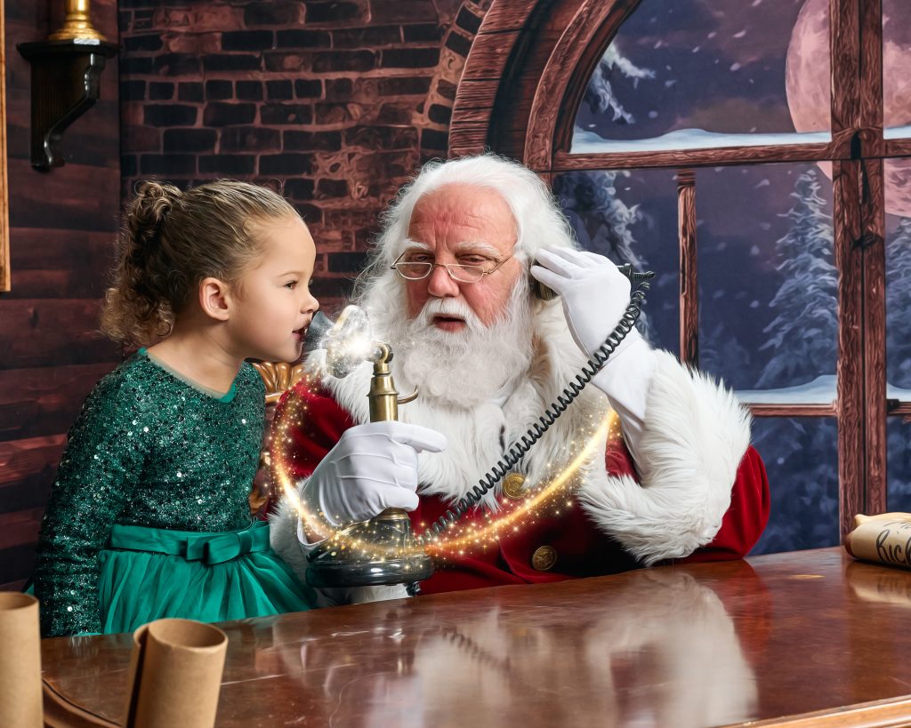 Little girl talking on phone with Santa and Head Elf