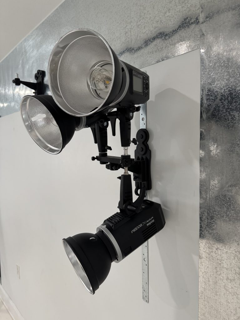 TogDrop® Vertical Inline Magnetic Base mounted on vertical strip holding three studio lights