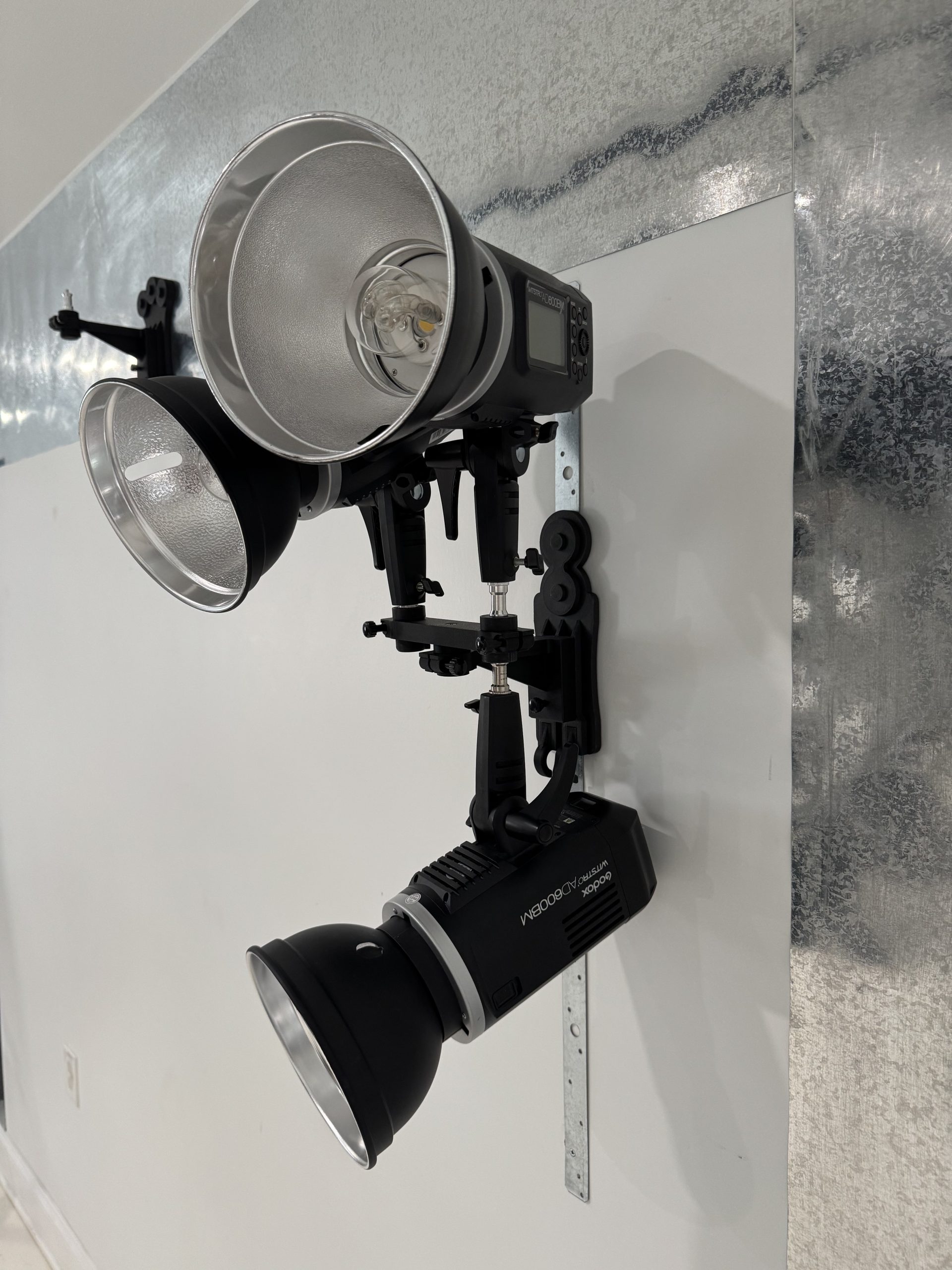 TogDrop® Vertical Inline Magnetic Base mounted on vertical strip holding three studio lights