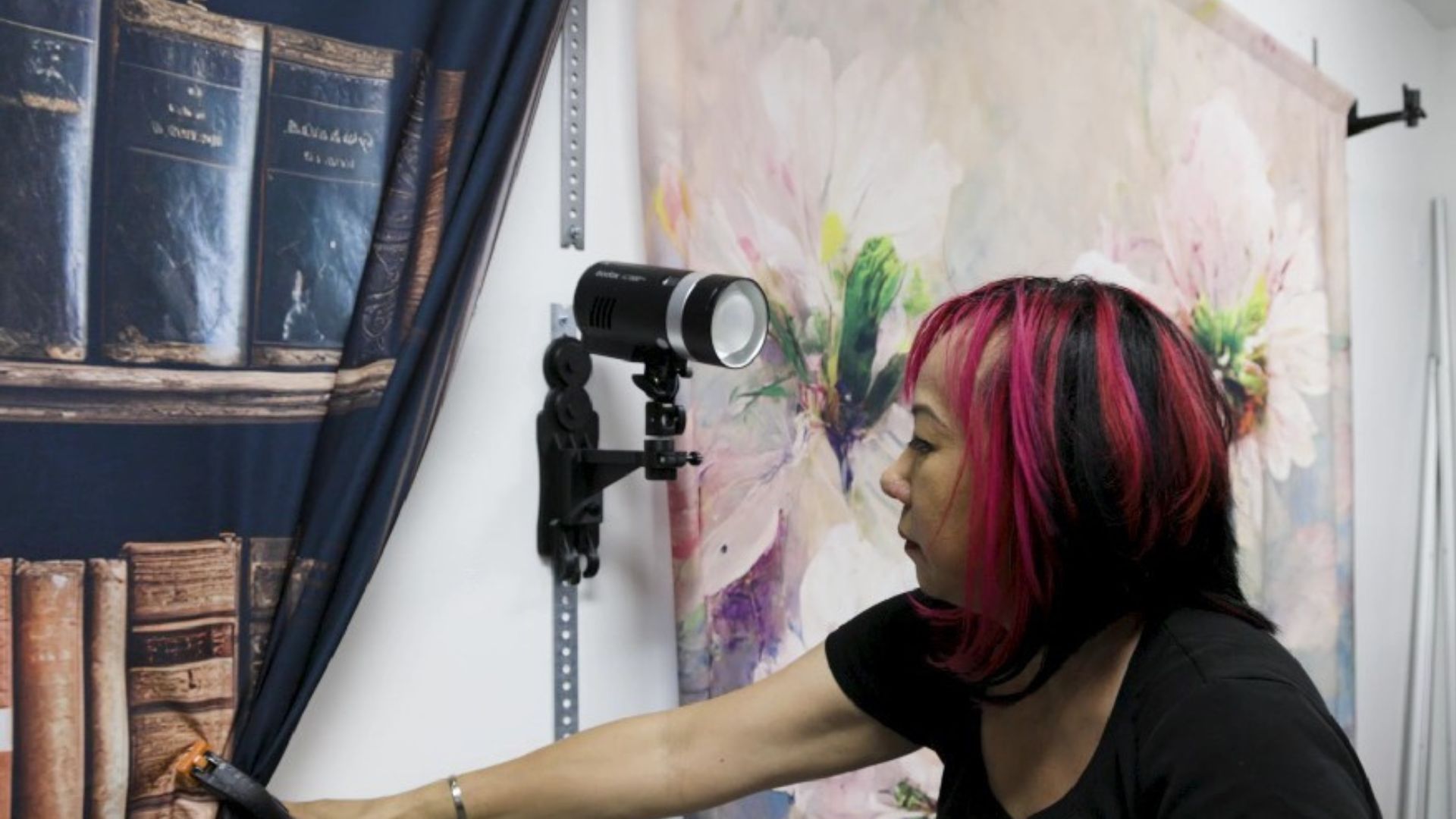 Small photography studio layout with multiple backdrops and lights on the wall system