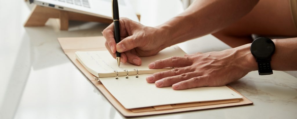 Photographer writing a task list to reduce decision fatigue and stay organized during peak season photography.