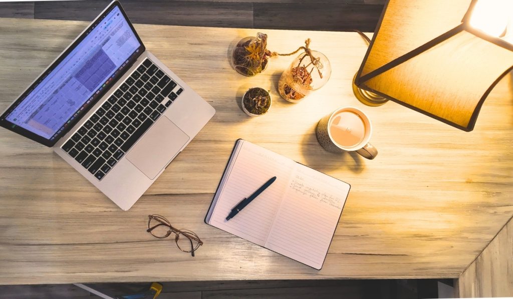 Photography business planning desk with laptop, calendar, and studio workspace