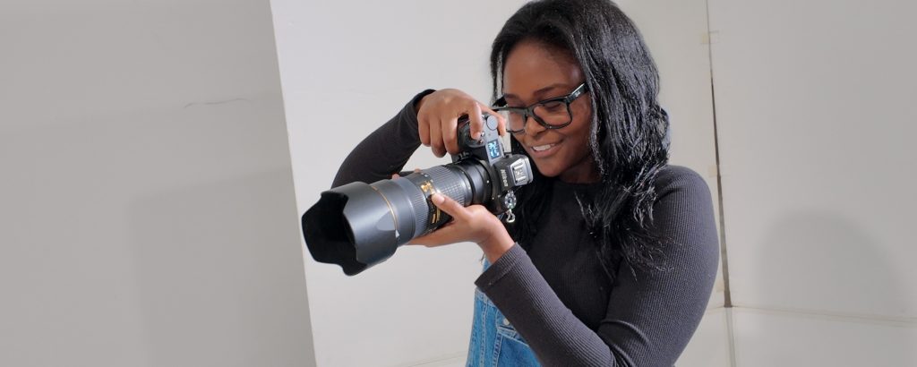 Photographer holding a camera while developing a personal photography style and creative voice