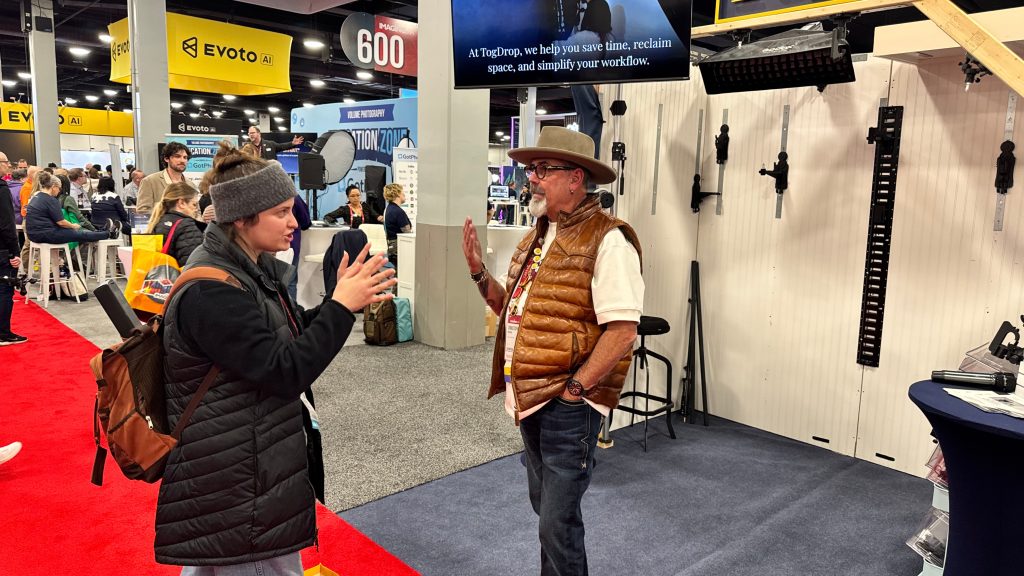 TogDrop customer speaking to a group of photographers at a conference booth sharing his studio workflow experience