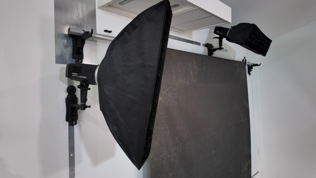 photography studio with wall mounted backdrop and multiple lights off the floor
