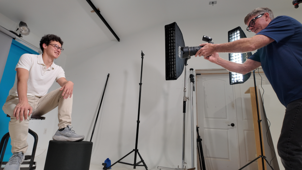 Photographer working in an organized studio setup with efficient lighting and backdrop workflow for portrait photography