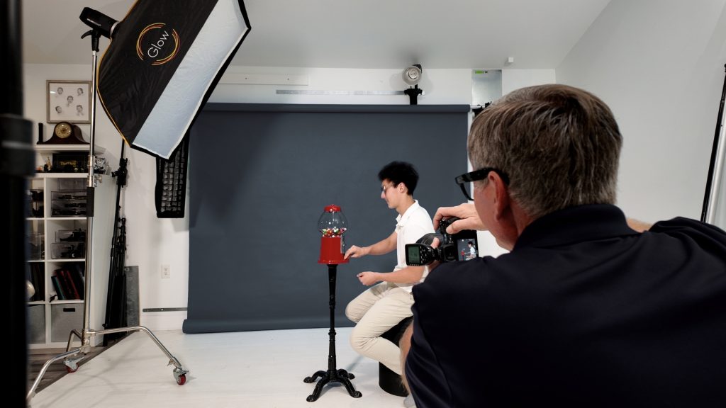 Photographer using a TogDrop backdrop system during a senior portrait session with fast studio workflow