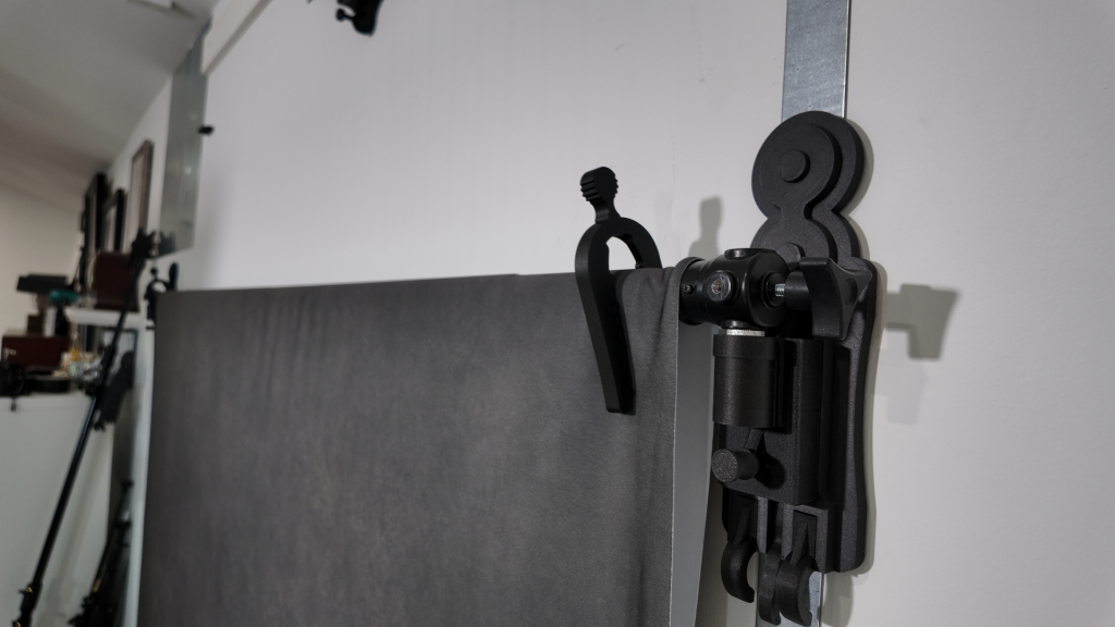 Close-up of wall-mounted backdrop system hardware holding a backdrop securely