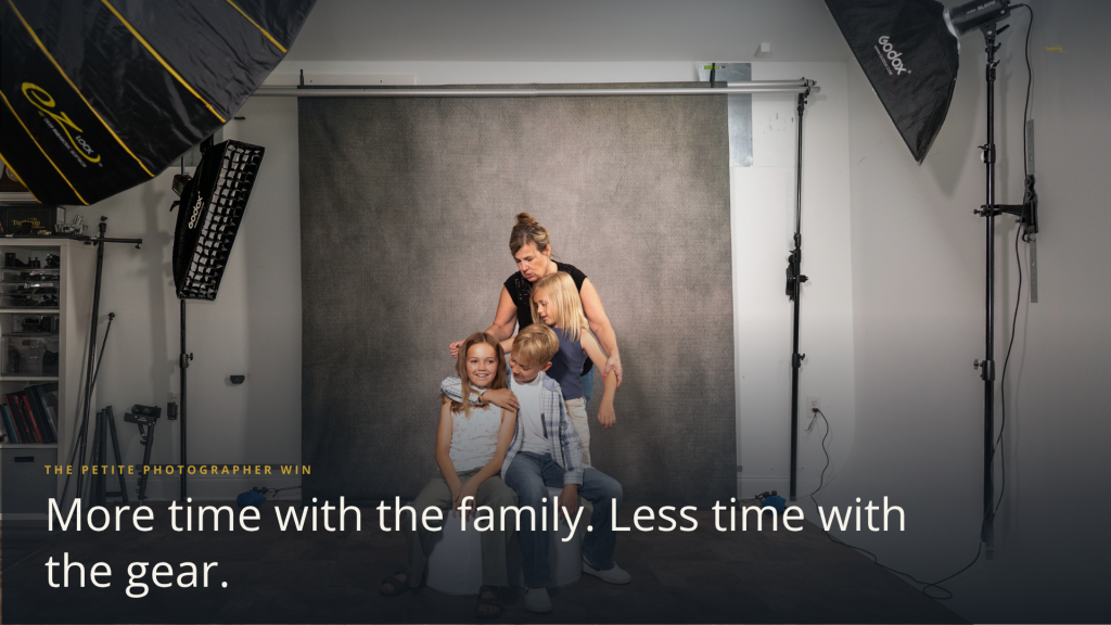 Family photographer working with children in a photography studio with clear floor space created by a wall-mounted backdrop system.