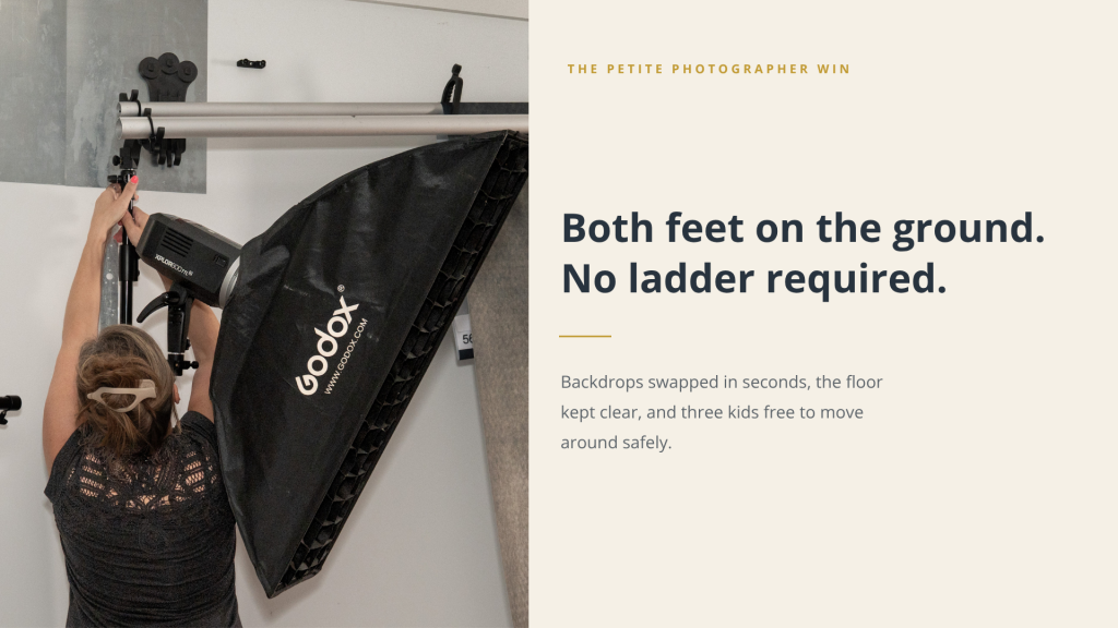 Petite photographer changing a photography backdrop without using a ladder using a wall-mounted backdrop system.