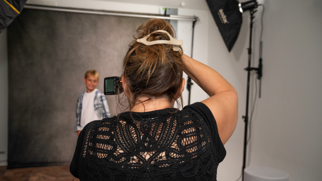 Photographer using integrated wall mounted studio lighting during a portrait session